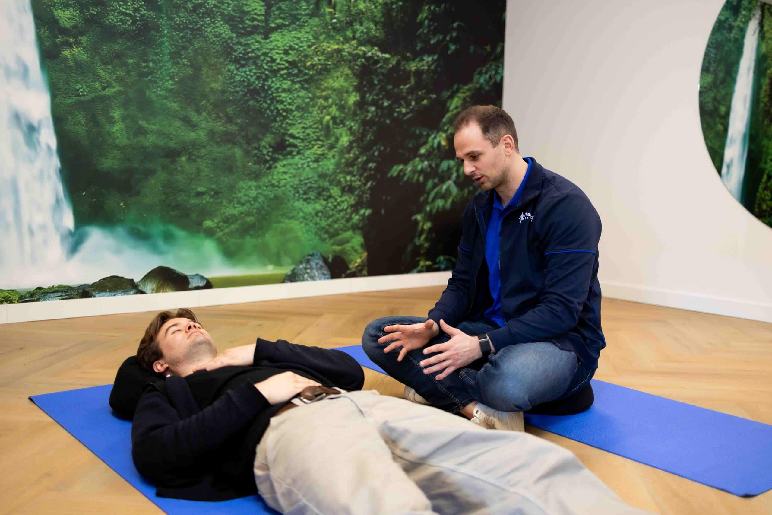 Fysiotherapeut Leon Slotboom begeleidt een cliënt bij ademhalingstherapie en ontspanning