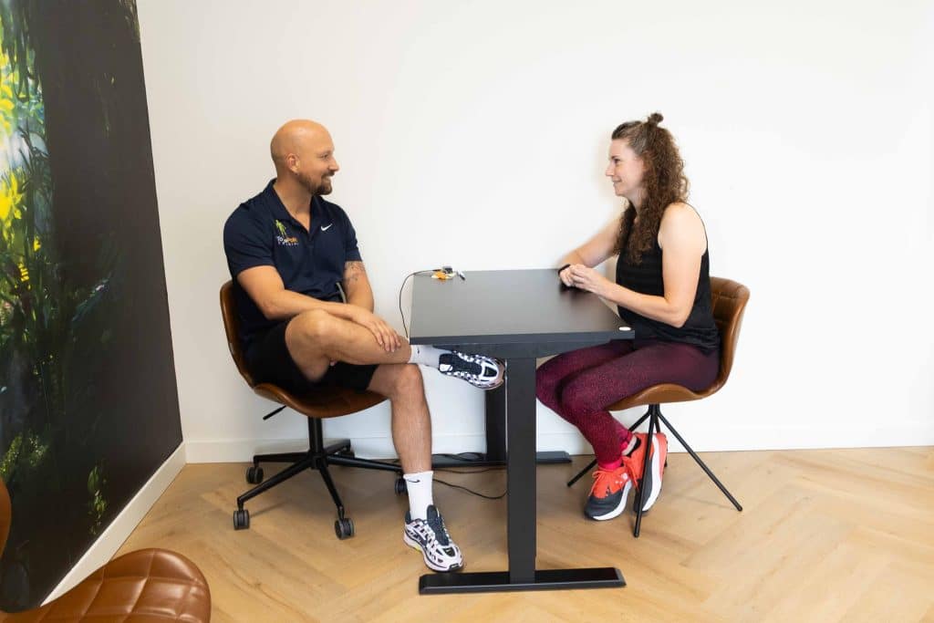 Coach Joop en klant Lionne in gesprek tijdens een persoonlijke coachingsessie aan tafel bij ToThePoint Training
