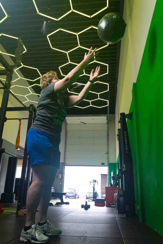 Marijke gooit een medicine ball tijdens haar training bij ToThePoint in Tiel